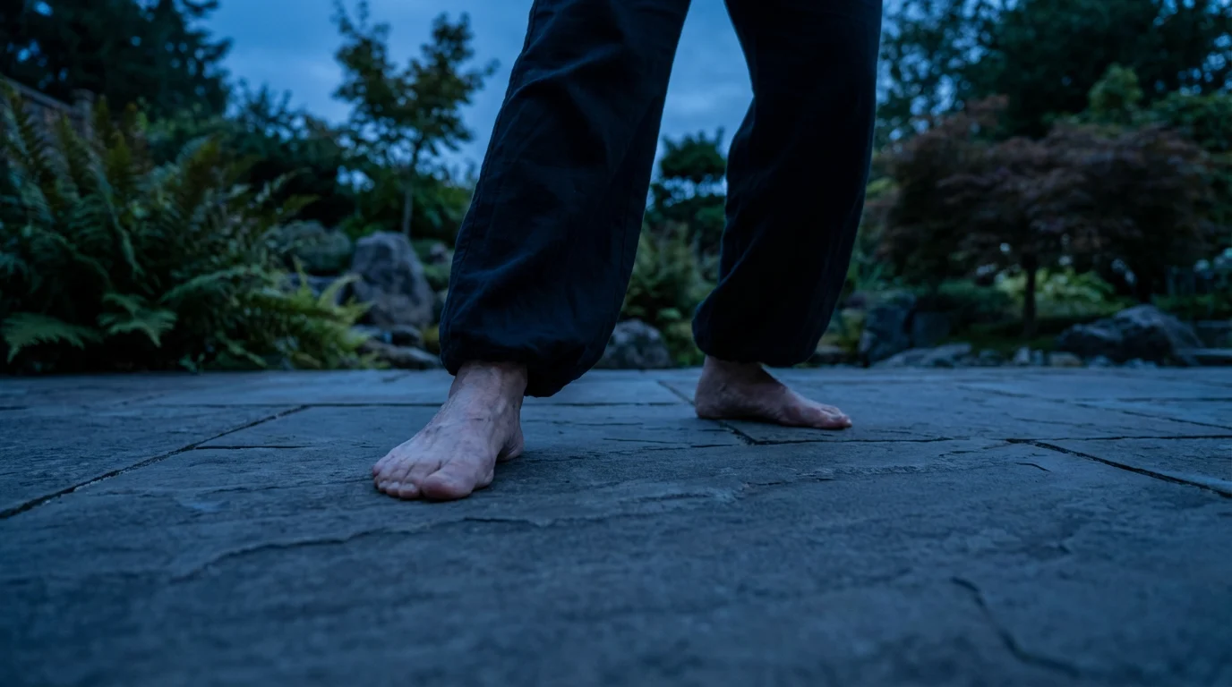 Low angle view of a senior woman's bare feet practicing a balance pose outdoors.